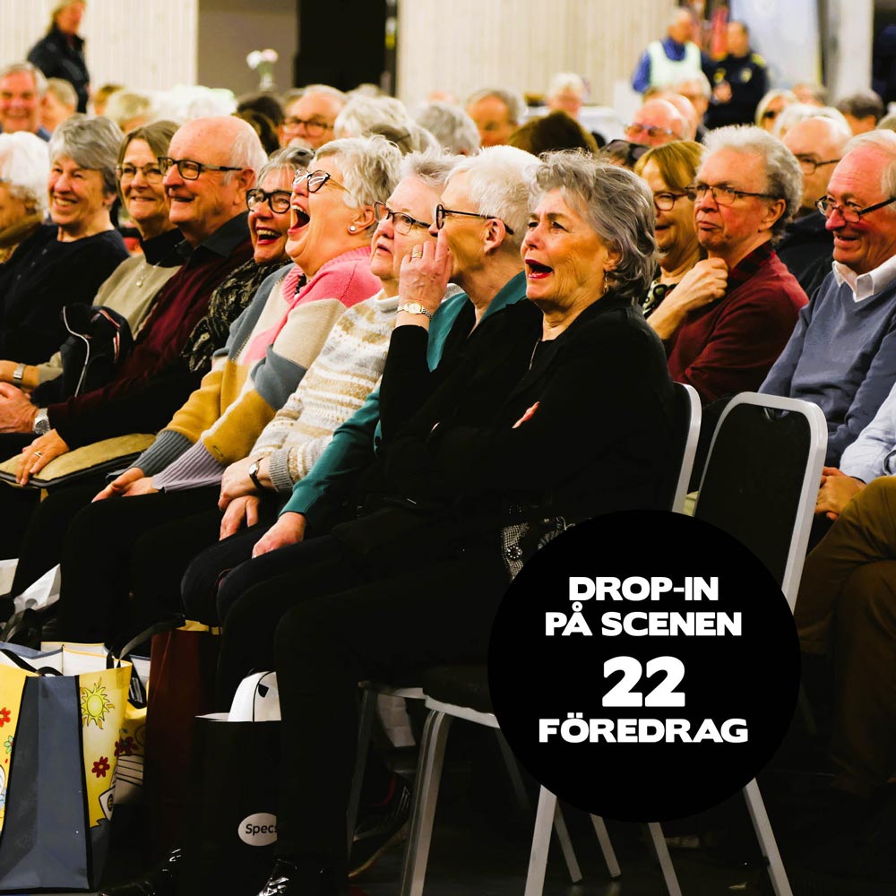 Besökare på mässan sitter vid scenen och skrattar